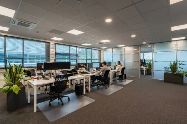 Modern kantoorinterieur aan de 1e Barendrechtseweg met werkplekken, computers en medewerkers aan het werk.